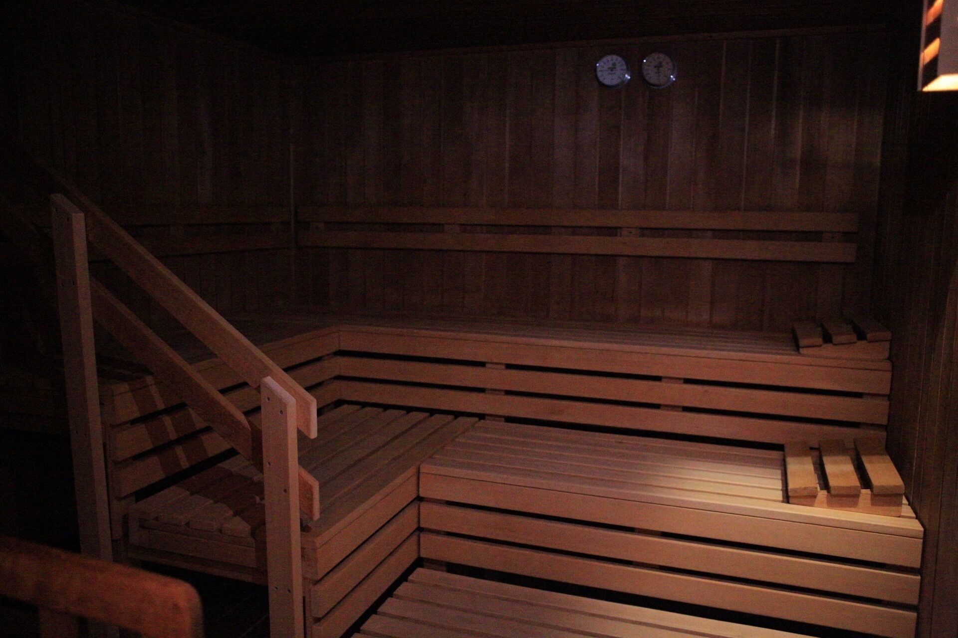 A sauna with wooden benches and a wooden staircase.