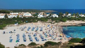 Ein Küstenresort mit Strandliegen, einem Sandstrand und freiem Blick auf das Meer.