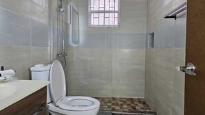 A bathroom with a toilet, sink, and shower. - Relax & Unwind in Our Tranquil Space at Jamaica b&b rentals (Montego Bay)