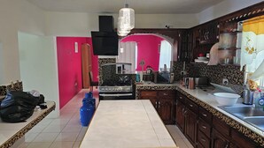 Una cocina con estufa a gas, microondas, tostadora y pileta.