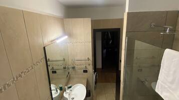 Baño con lavabo, espejo y ducha.