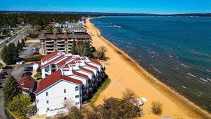 Ein Küstenhotel mit mehreren Gebäuden, einem Sandstrand und freiem Blick auf das Meer.