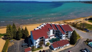 Ein mehrstöckiges Hotel mit rotem Dach in Strandnähe und freiem Blick auf den Ozean.