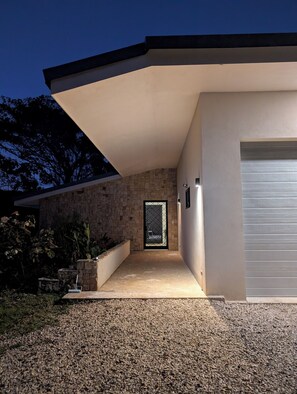Una casa moderna con fachada de piedra, un porche cubierto y un garaje.