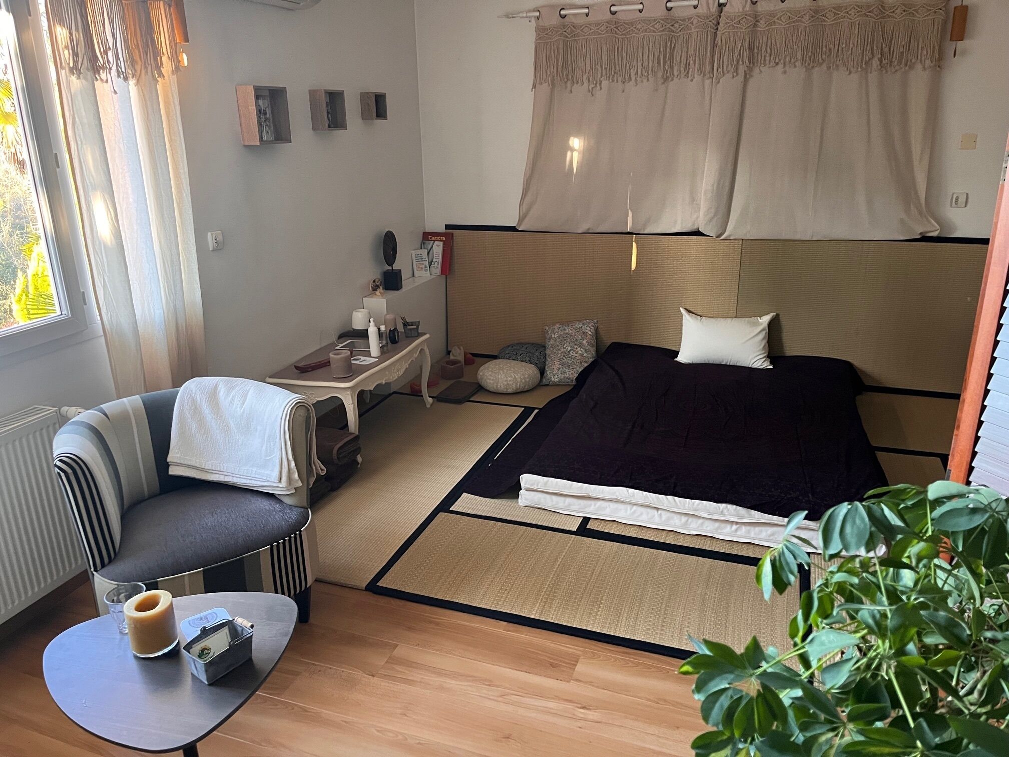 Une chambre d’hôtel compacte comprenant un lit, un petit coin salon, une table de chevet avec des articles de toilette et une vue sur l’extérieur.