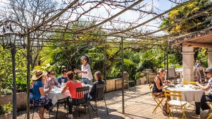 An outdoor dining area with tables and chairs, surrounded by greenery and a pergola structure. - Maison Tournesol Pau Jurançon Gan (Gan)