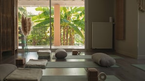 A yoga room with mats, blocks, and a view of tropical plants. - Maison Tournesol Pau Jurançon Gan (Gan)