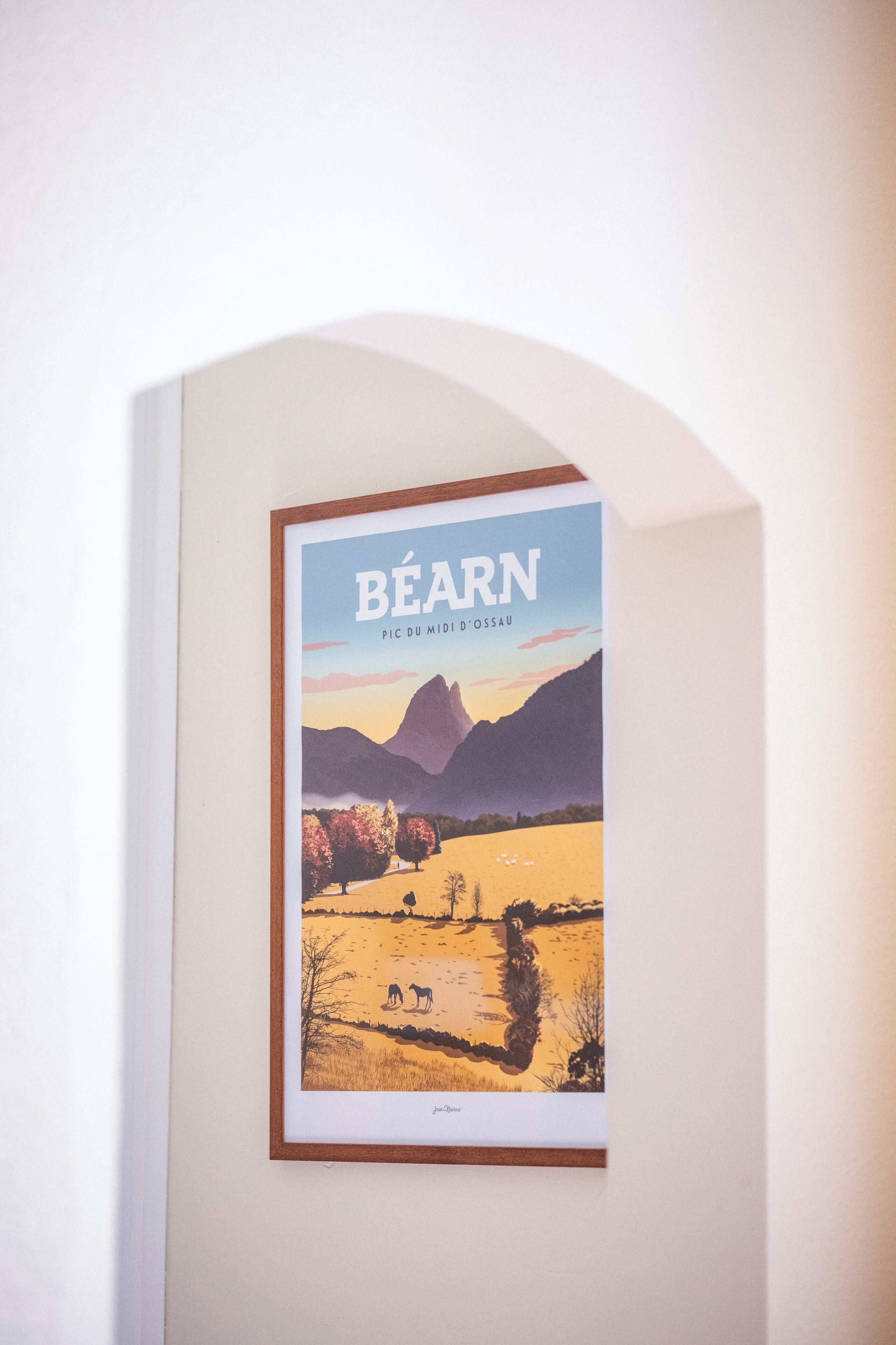 A framed picture of a landscape with mountains and trees, titled "Béarn."