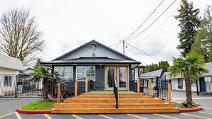 A building with a front entrance, steps, and a parking lot.