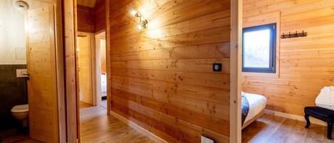Un intérieur en bois avec un lit, une table de chevet et une fenêtre.