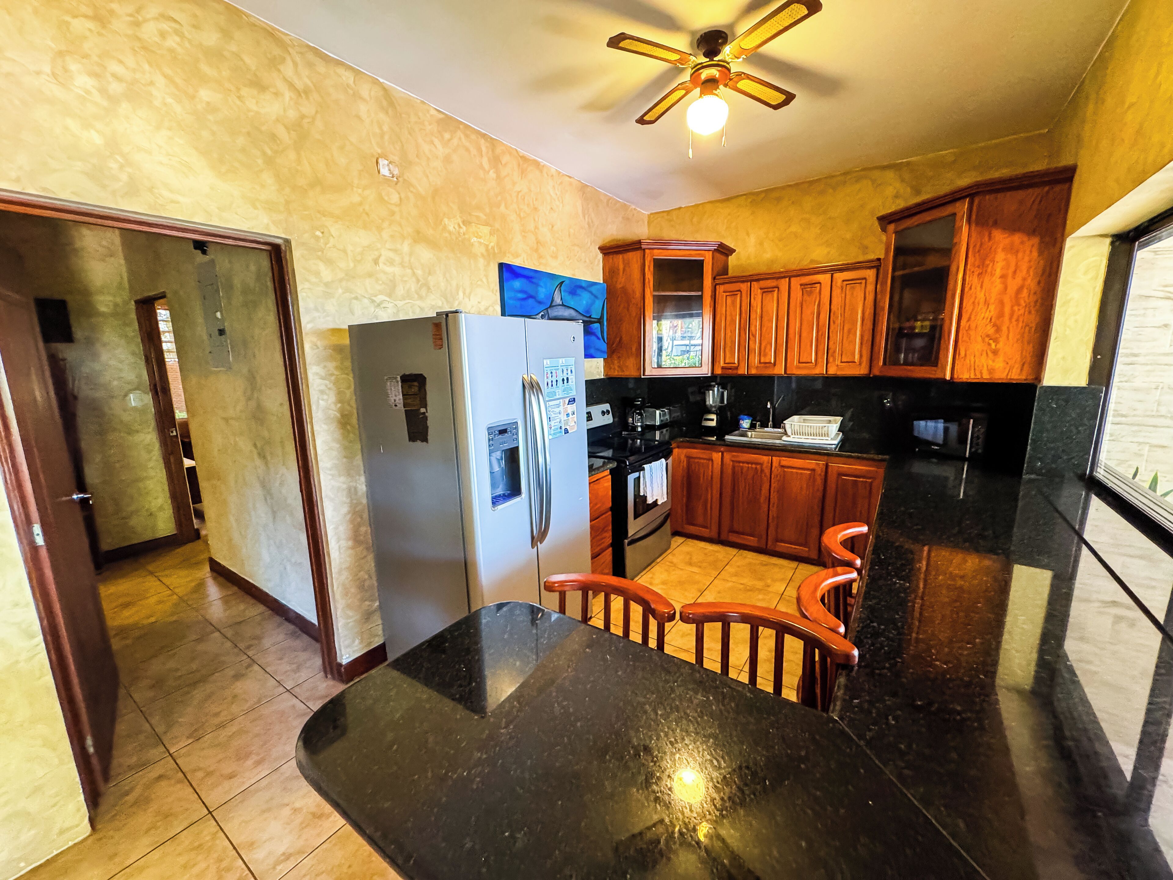 A kitchen with wooden cabinets, a refrigerator, a stove, and a dining table.