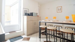 Una cocina moderna con comedor, que cuenta con un ventanal grande, microondas y cafetera.