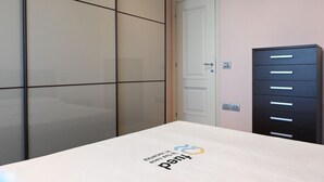 Una stanza con un letto, un armadio e una porta.