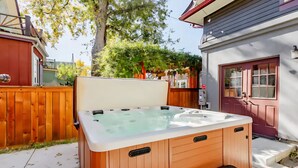Ein hölzernes Whirlpool mit Sitzbank in einem Garten.