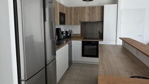 Una cocina moderna con electrodomésticos de acero inoxidable, armarios de madera y encimera de madera.