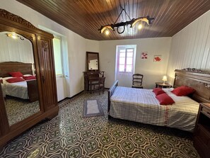 Traditional hotel room with a large mirror, comfortable bed, and a desk area.