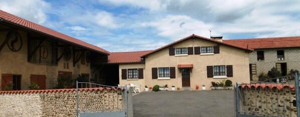 Stunning building with a traditional pitched roof and symmetrical facade, featuring a central entrance and secure perimeter.