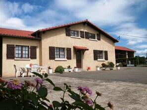 Guests can relax in the outdoor seating area surrounded by lush greenery and potted plants.