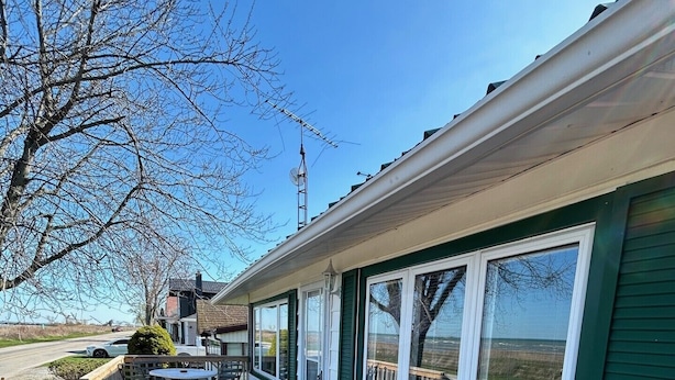 A wooden deck with outdoor seating and large windows. - Waterfront 3 Bedroom cottage located in beautiful Turkey Point (Vittoria)