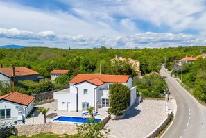 Un quartier résidentiel avec des maisons, une piscine et une route.
