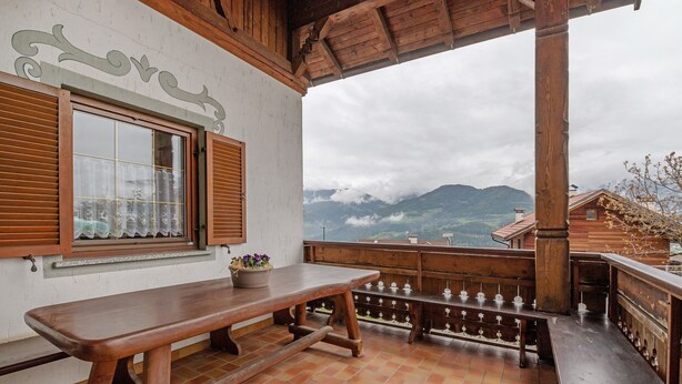 A wooden table and bench on a terrace with a view of mountains. - Apartment 'Klein' with Mountain View, Shared Garden and Wi-Fi (Velturno)