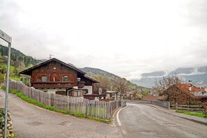 A wooden house with a balcony, a wooden fence, and a curved road. - Apartment 'Groß' with Mountain View, Shared Garden and Wi-Fi (Velturno)