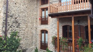 A stone building with a wooden balcony, arched windows, and potted plants. - Apartment 'Casa Mary Castagno' with Wi-Fi (Prabione)