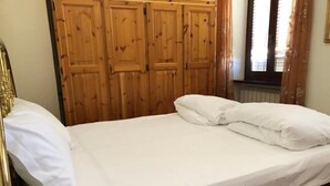A single bed with white bedding in a room with wooden paneling and a radiator. - Apartment 'Casa Mary Castagno' with Wi-Fi (Prabione)