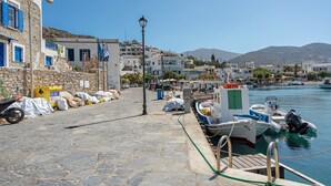 A coastal town with stone buildings, a dock with boats, and a clear sky. - Apartment 'Nicolas House 2' with Sea View, Private Terrace and Air Conditioning (Rakhídhion)