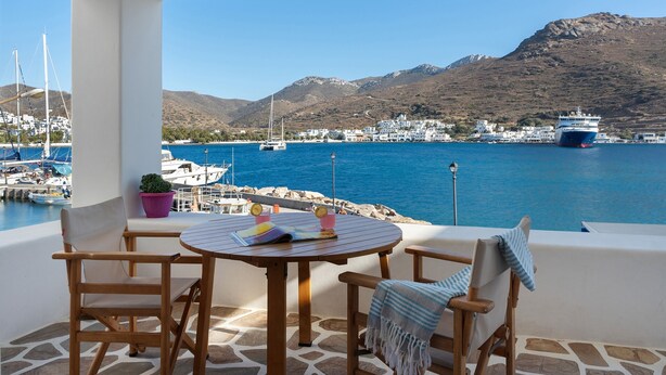 A terrace with a table and chairs, overlooking a harbor with boats and a mountainous backdrop. - Apartment 'Nicolas House 2' with Sea View, Private Terrace and Air Conditioning (Rakhídhion)