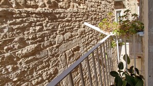 A stone wall with a metal railing and a potted plant. - Apartment 'Home Sweet Home' with Balcony, Wi-Fi and Air Conditioning (Giovinazzo)