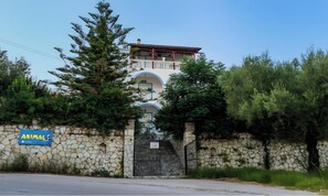Un bâtiment doté d’un mur en pierre, d’une porte et d’une enseigne sur laquelle on peut lire « ANIMAUX ».