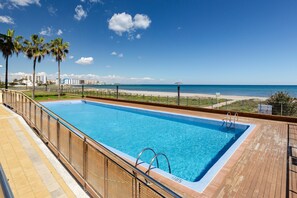 Piscina com vista para a praia e oceano.
