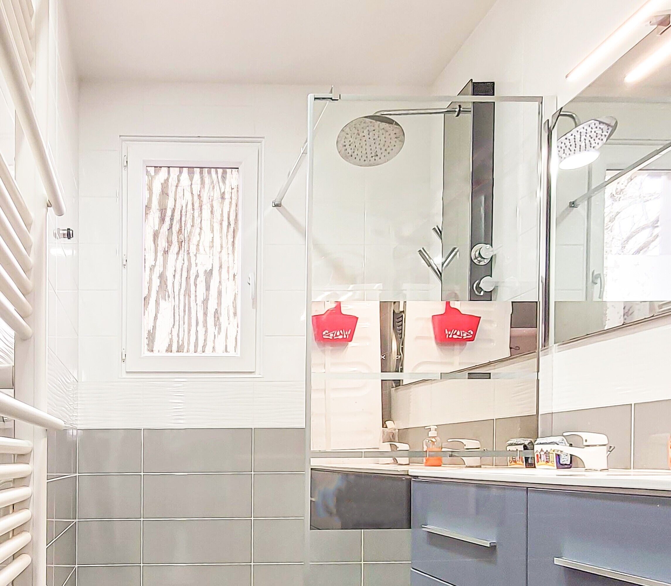 A bathroom with a shower, a sink with a mirror, and a towel rack.