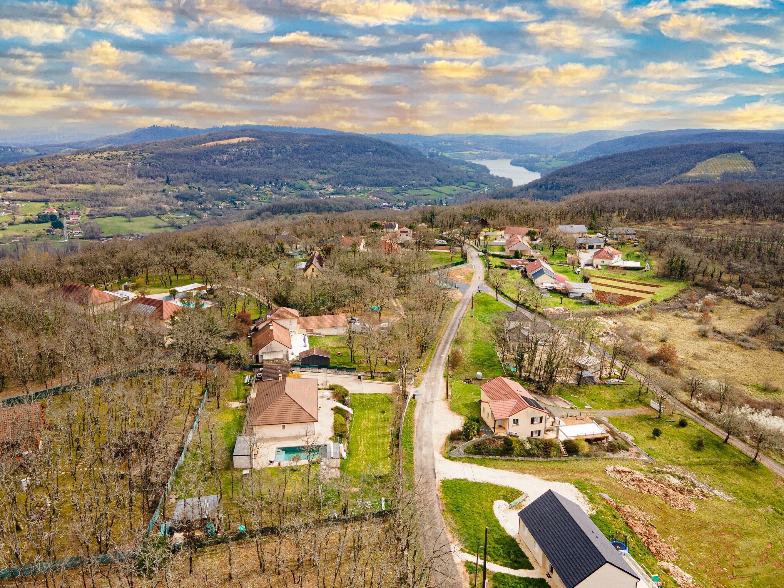 A residential area with houses, a road, and a river in the background.