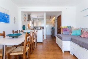 Ein Essbereich mit einem weißen Tisch, Holzstühlen und Sitzgeflächen aus Bändern.