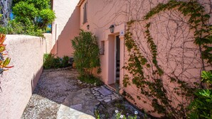 A narrow alleyway with a building entrance, a stone pathway, and greenery. - Holiday Home 'Maison De Gathen' with Sea View, Shared Pool and Air Conditioning (Cavalaire-sur-Mer)