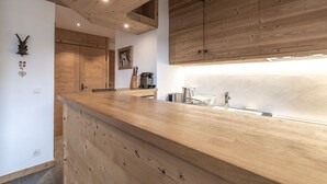 Una cocina moderna con armarios de madera, encimera de madera y pileta integrada.