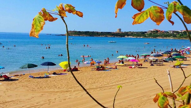 A beach with people, umbrellas, and boats. - Villa surrounded in nature (Isola di Capo Rizzuto)