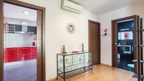 A modern kitchen with red cabinets, a glass display case, and a decorative mirror. - 'Denia Sur' Apartment with Mountain Views, Wi-Fi, and Air Conditioning (La Xara)