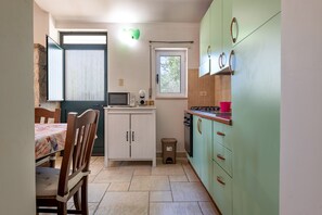 A compact kitchen with a microwave, stove, and cabinets.