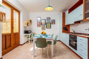 A kitchen with a dining table, chairs, a stove, and a microwave. - Apartment 'Home Centrum 2' with Sea View, Wi-Fi and Air Conditioning (Giarre)