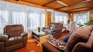 A cozy living room with wooden ceiling beams, a brown leather sofa, a brown leather armchair, and a glass coffee table. - Holiday apartment with air conditioning and terrace (Dramalj)