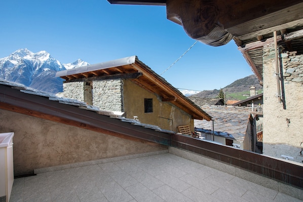 A mountain view with a stone building and a wooden structure.