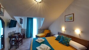 Un dormitorio con cama, escritorio, silla y televisor.