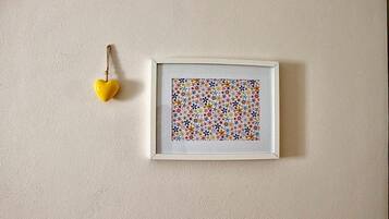 Ein gerahmtes Kunstwerk mit einem farbenfrohen Blumenmuster an einer strukturierten Wand.