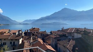 A town with terracotta-roofed buildings, a lake, and mountains in the background. - Apartment 'Liivv House  - Lake Como' with Lake View, Private Terrace and Wi-Fi (Gravedona ed uniti)