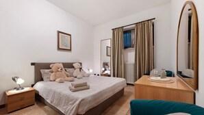 A bedroom with a bed, bedside tables, a dresser, a mirror, a teddy bear, and a blue sofa. - Apartment 'Liivv House  - Lake Como' with Lake View, Private Terrace and Wi-Fi (Gravedona ed uniti)