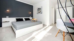 Une chambre moderne avec un grand lit, des tables de chevet, un bureau et une chaise.