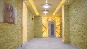 A hallway with brick walls, a marble-patterned wall, and a door with intricate designs. - Mak Pyramids View (Giza)